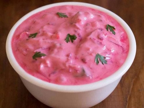 beetroot raita in white glass bowl on a wooden board