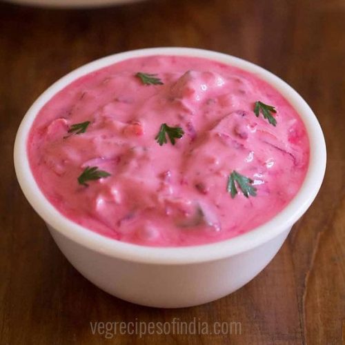 beetroot raita in white glass bowl on a wooden board