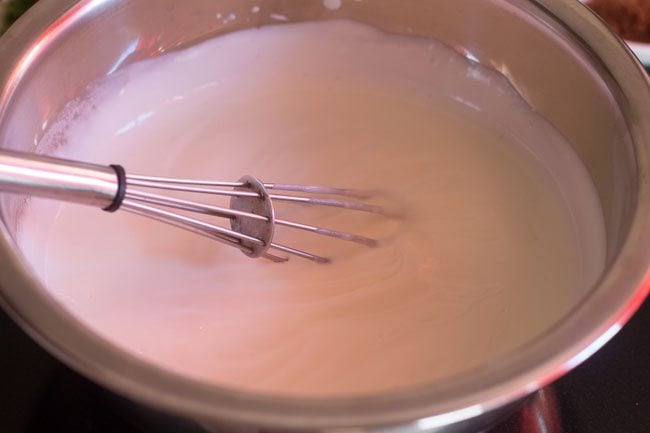 curd being whisked in a steel bowl