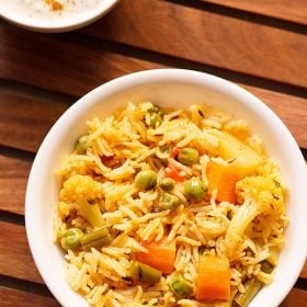 instant pot veg pulao served in a white bowl on a wooden tray