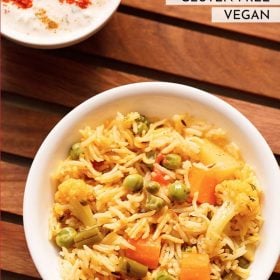 instant pot pulao served in a white bowl on a wooden tray with a bowl of raita kept in the background.