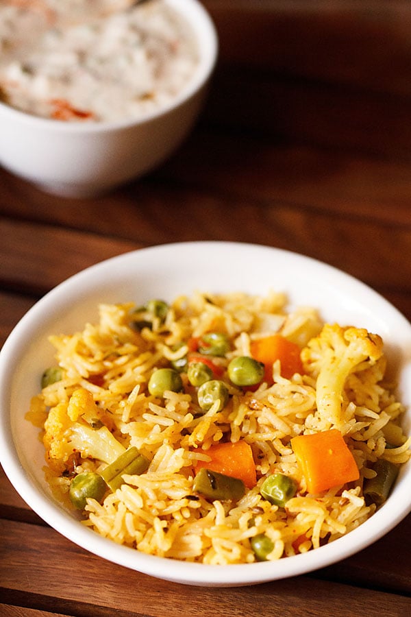 instant pot veg pulao served in a white bowl on a wooden tray