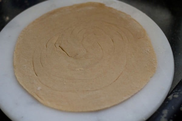 rolled lachha paratha on a rolling board