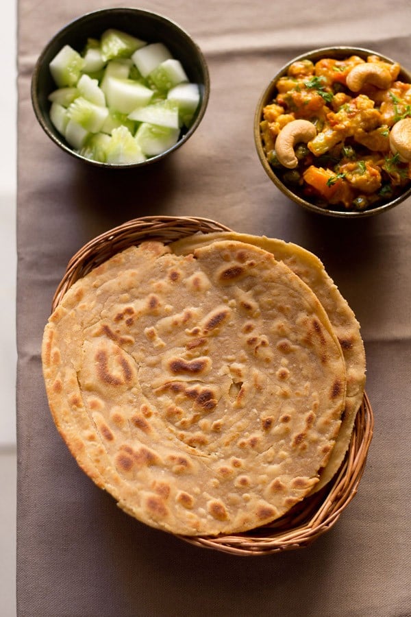 Lachha Paratha served in a cane basket with gravy dish and salad