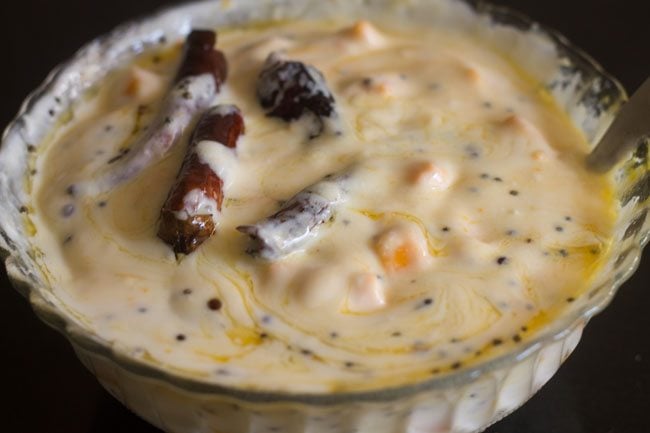 mixing the tempering in the mango raita