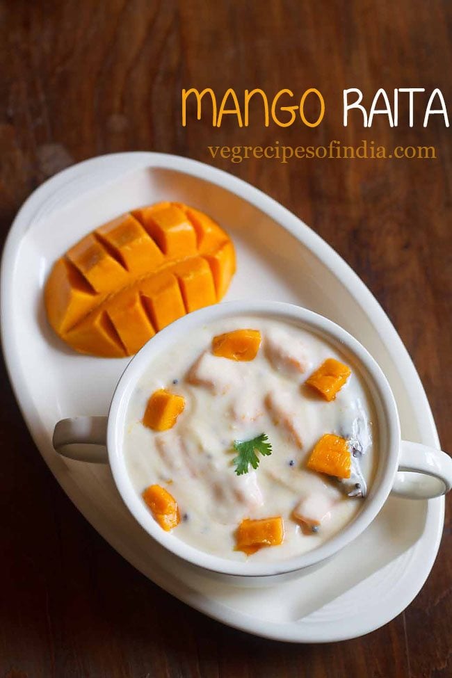 mango raita topped with mango cubes in a white bowl.