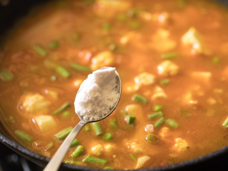 teaspoon of salt over pot of mixed vegetables 