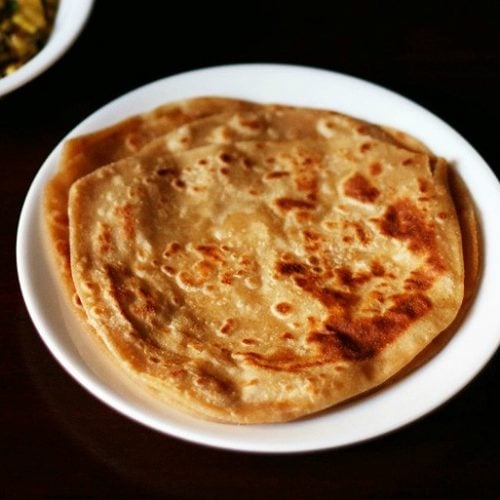 plain paratha served on a white plate.