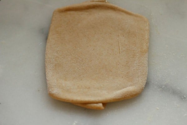 rolling paratha on a board