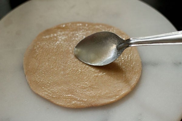 applying oil on rolled paratha