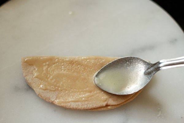 applying oil on rolled paratha