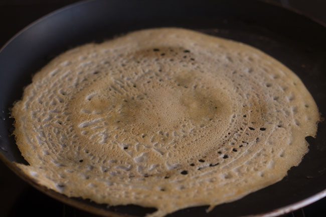 flipping and cooking dosa on other side