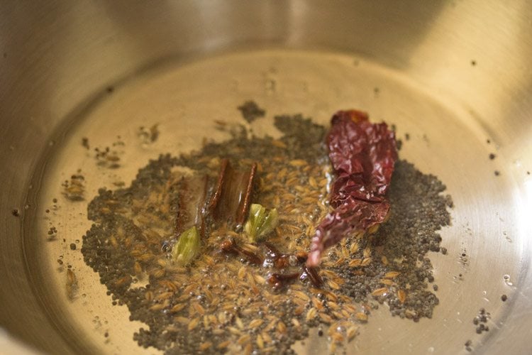 frying cinnamon, green cardamoms, cloves and dried red chili 