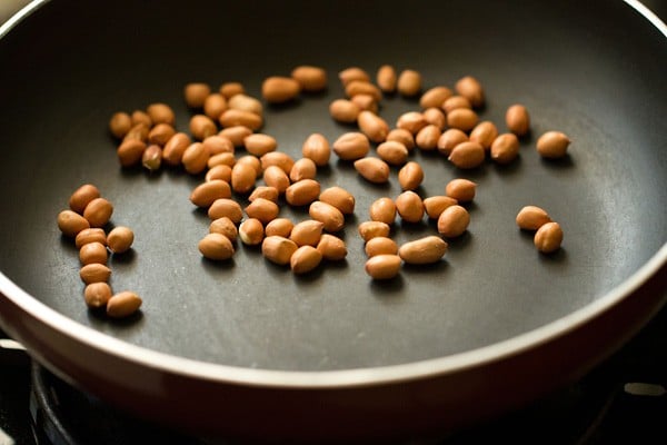 peanuts added to hot pan for making aloo poha.