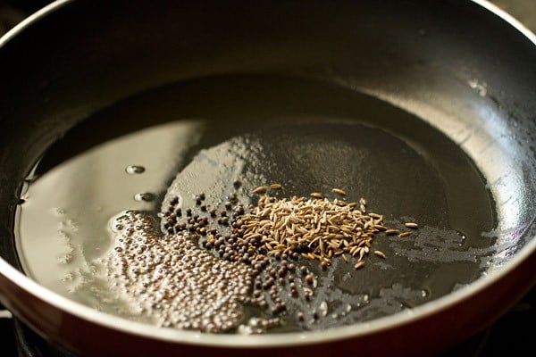 mustard seeds and cumin seeds added to hot oil in pan.