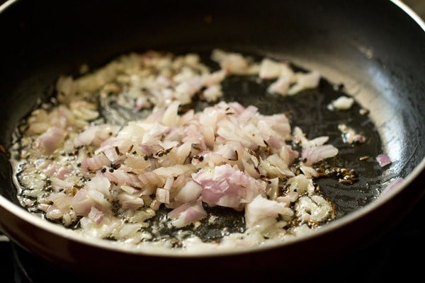 finely chopped onions added to pan for making batata poha.