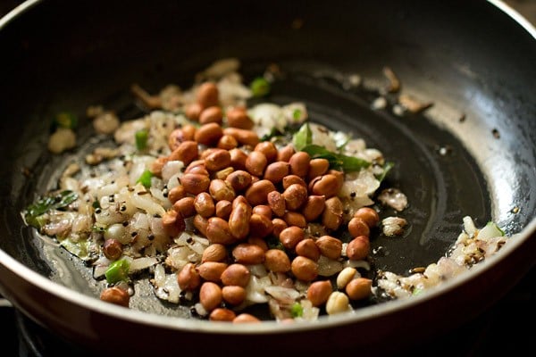 roasted peanuts added to onion mixture for making batata poha.