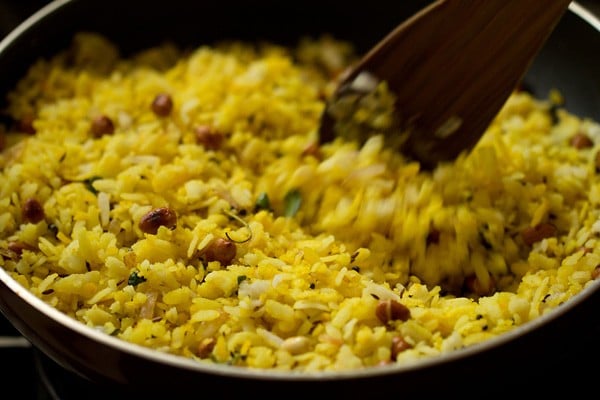 mixing poha mixture with onion mixture.