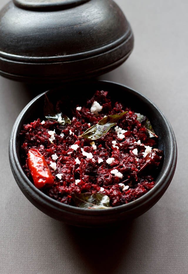 beetroot thoran served in a black bowl with its lid kept on the top side. 