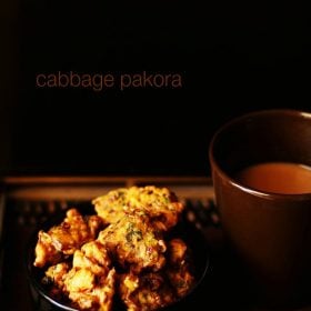 cabbage pakoda served on a black bowl with tea