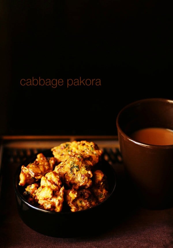 cabbage pakoda served on a black bowl with tea.