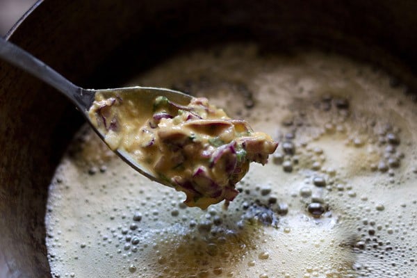 add pakora batter to medium hot oil in a kadai or pan