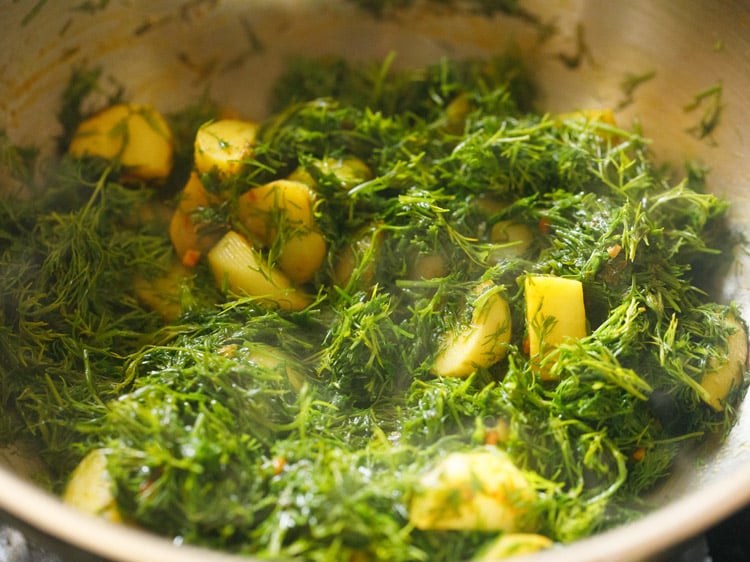 mixing dill leaves with potatoes