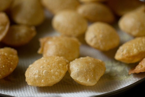 fried puri placed on kitchen paper towels