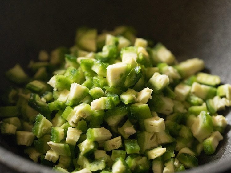 chopped karela added to kadai with oil