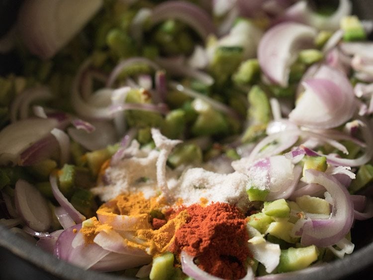 adding spices to the karela onion mixture