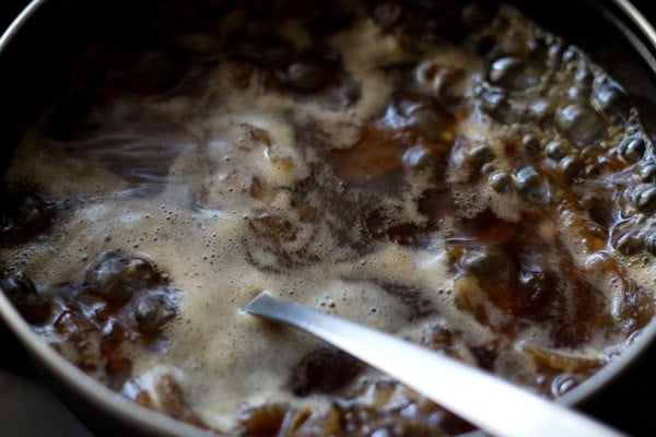 jaggery added and the mixture being mixed with a spoon