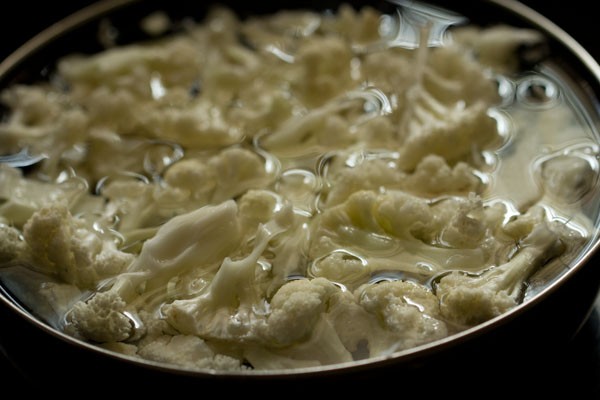 blanching gobi florets in hot water in a bowl