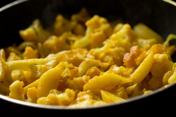 cooking aloo gobi stirring often at intervals