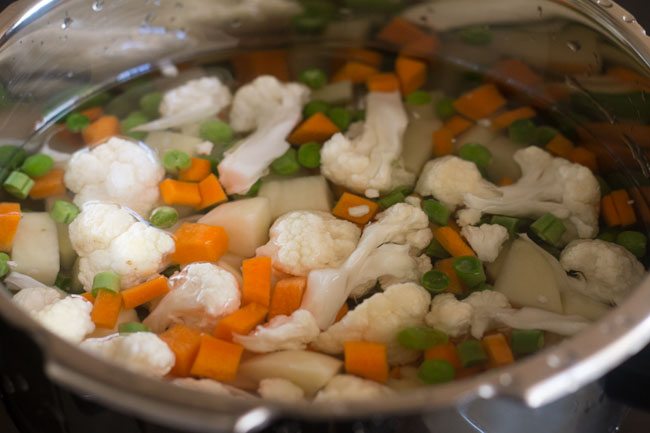 chopped veggies in pressure cooker with water