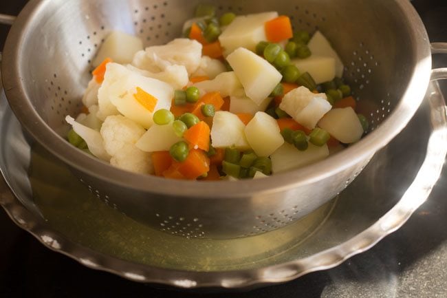 straining water from the cooked veggies