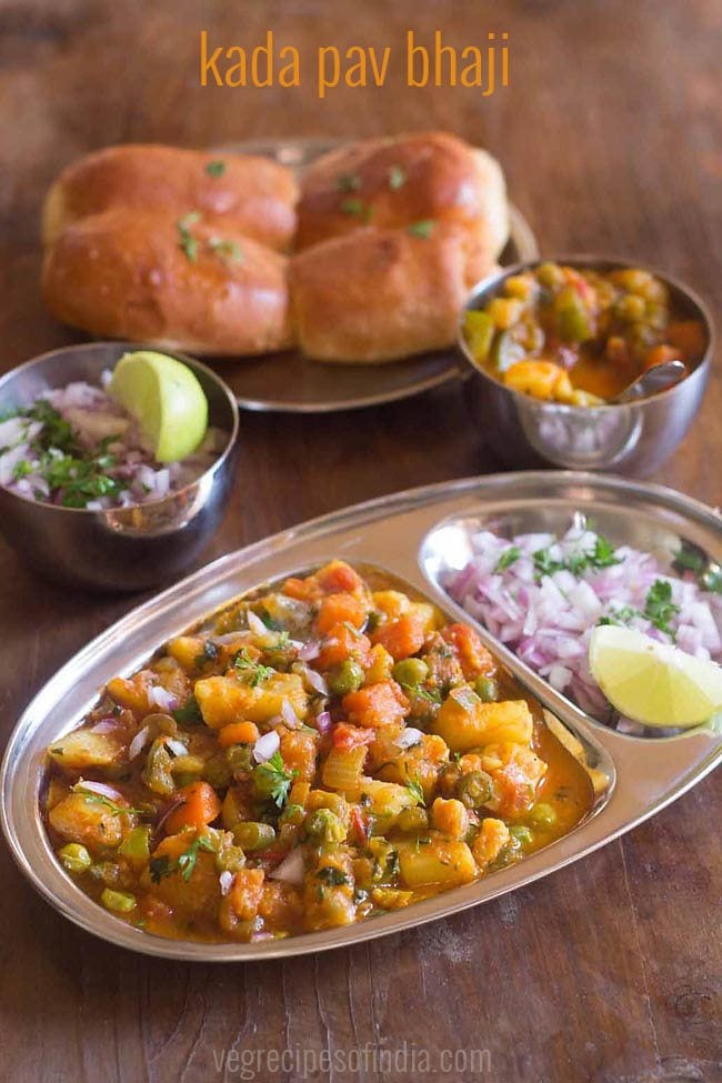 kada pav bhaji served in a plate with sides of pav and chopped onions, lemon wedges