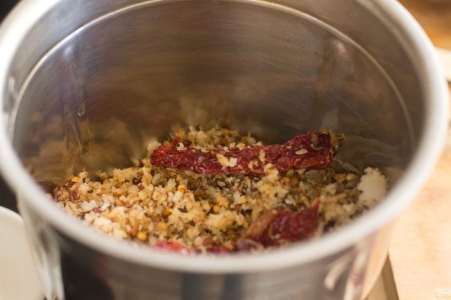 roasted spices and coconut mixture added into a grinder or blender.