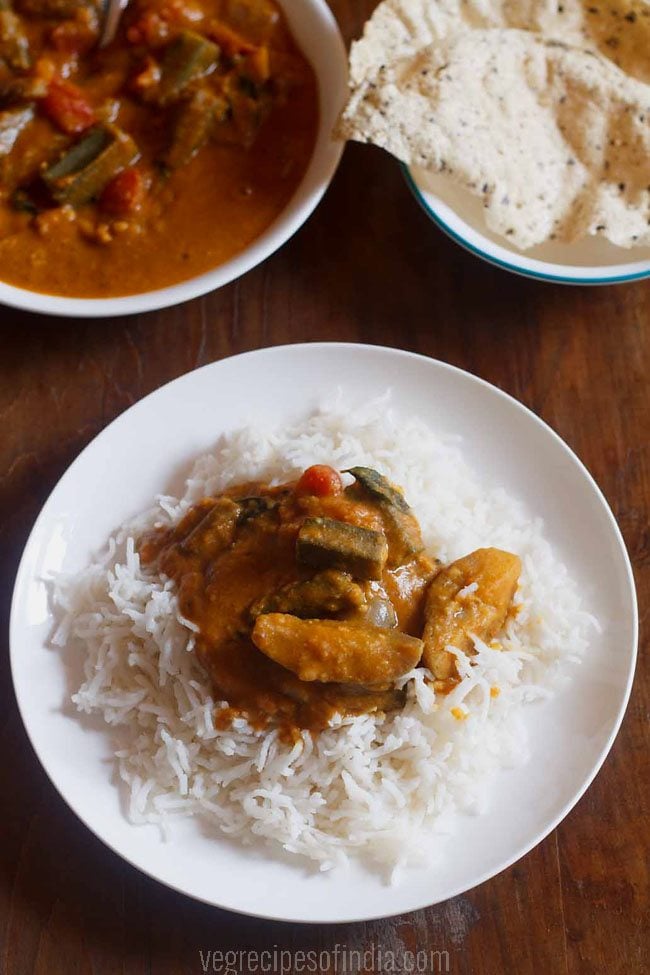 Kerala sambar served with rice on a round white plate and papad alongside