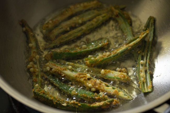 frying marinated sliced bhindi in hot oil. 