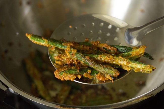 prepared kurkuri bhindi on a slotted spoon.