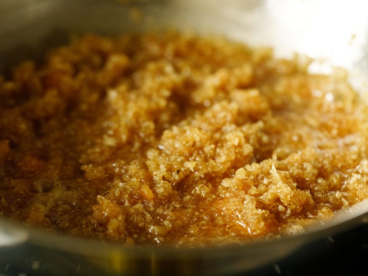 cooking coconut and jaggery on a low flame