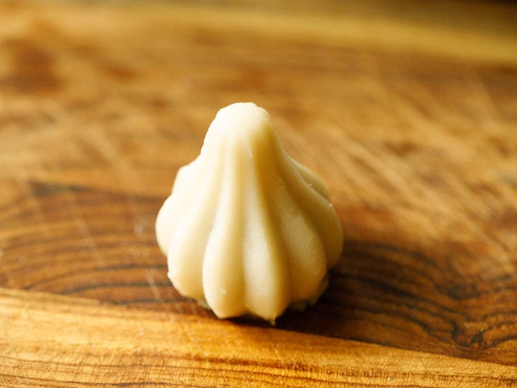 modak shaped with the modak mould placed on wooden board