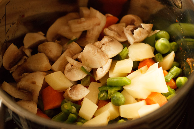 adding veggies to Thai red curry paste