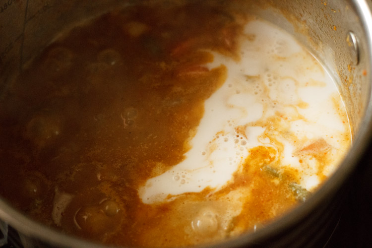 adding thick coconut milk to Thai red curry