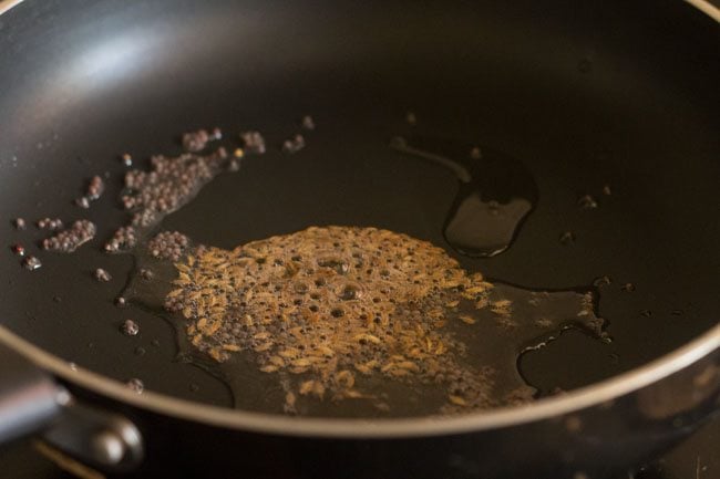 cumin seeds added to the pan. 