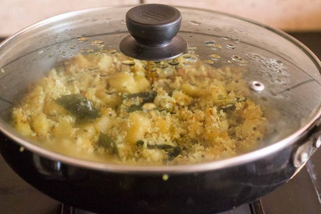 cooking the ash gourd thoran in the covered pan. 