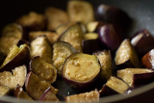 sautéed baingan is lightly golden and slightly shriveled.