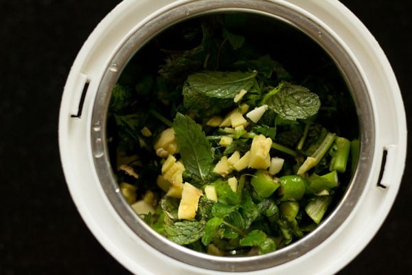 in a grinder jar add ginger garlic mint leaves coriander leaves and green chili
