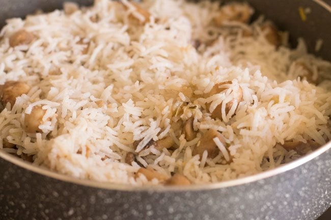 mixing mushrooms with cooked rice