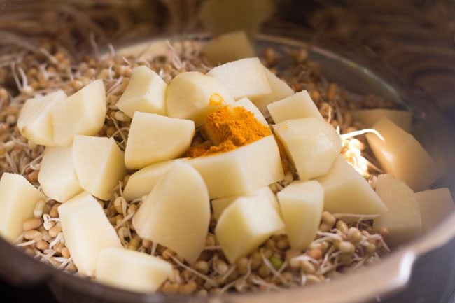 potatoes and turmeric powder added to sprouts